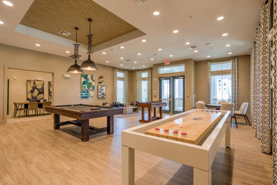 Game room featuring shuffleboard, poker table, billiards and foosball